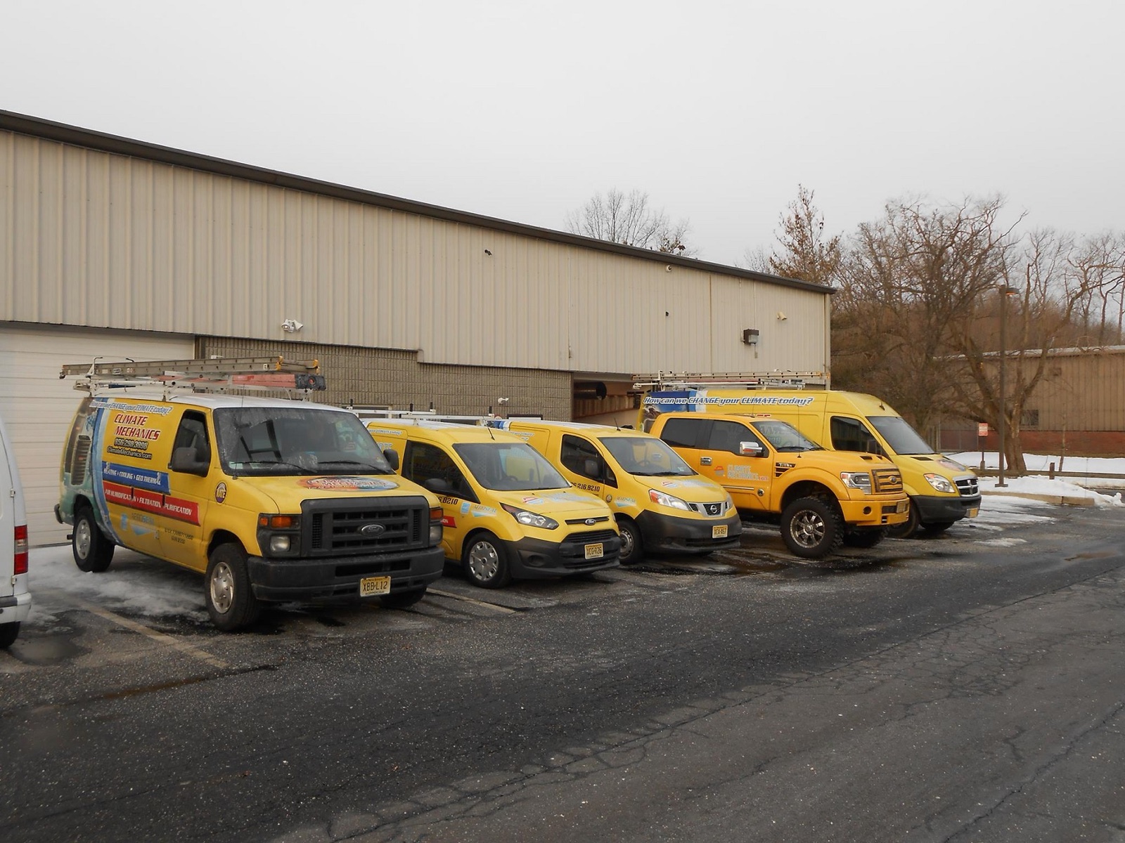 The branded yellow Climate Mechanics service fleet at the Cinnaminson shop