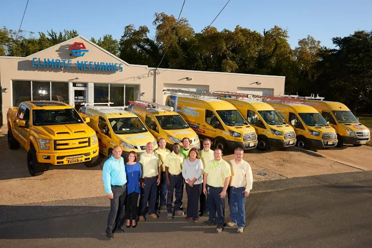 The Climate Mechanics team and bright-yellow service van fleet in front of their Cinnaminson, NJ headquarters